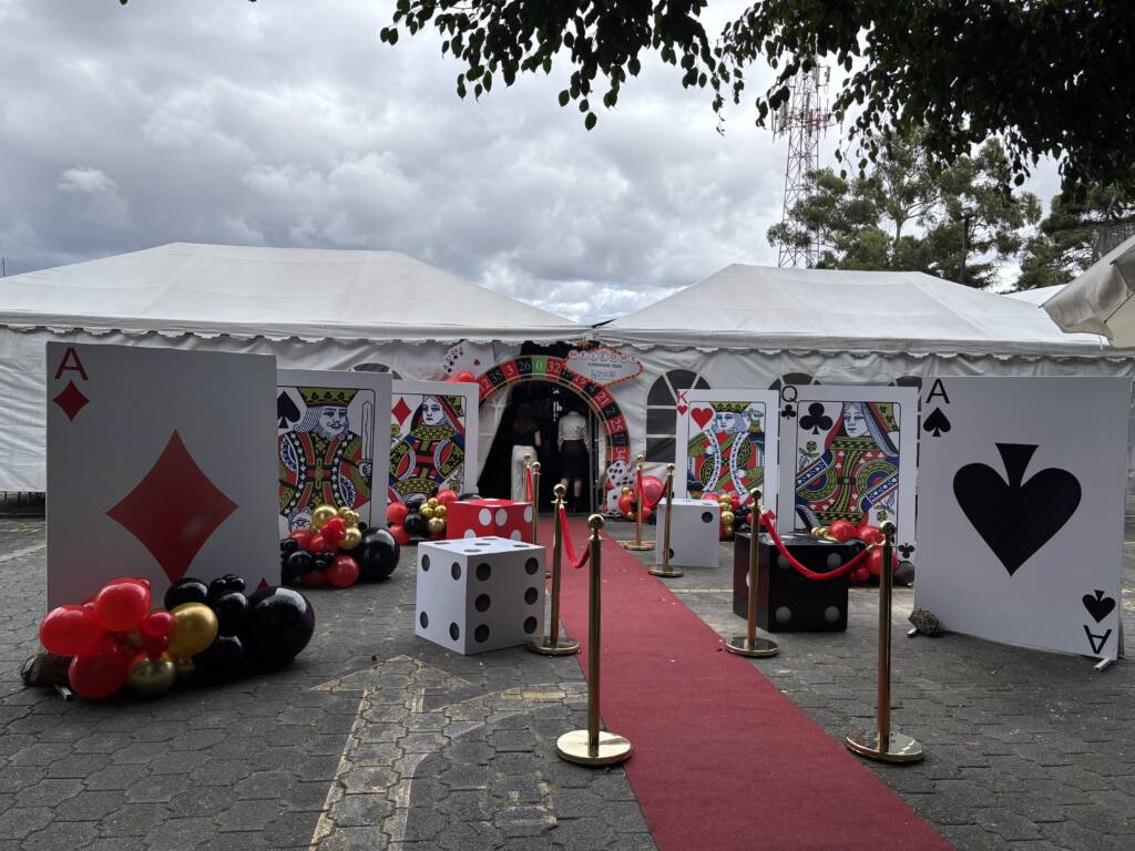 Ideas para convivio de fin de año: alfombra roja, cartas gigantes y arco de ruleta en la entrada del evento