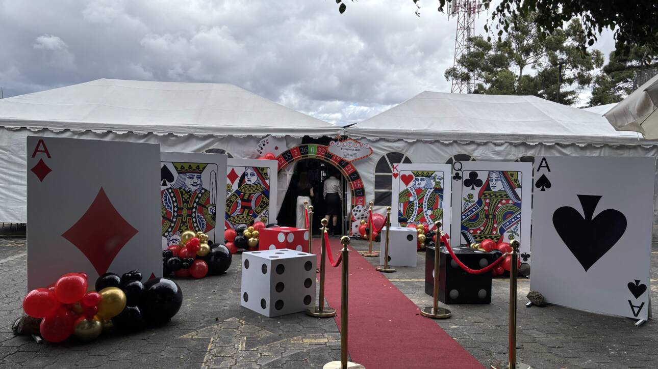 Ideas para convivio de fin de año: alfombra roja, cartas gigantes y arco de ruleta en la entrada del evento
